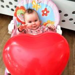 Uśmiechnięta dziewczynka z balonem w kształcie serca