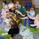 Pani Wiosna rozdaje dzieciom kwiatuszki z papieru