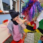 Ciocia przebrana za klauna maluje twarze dzieciom