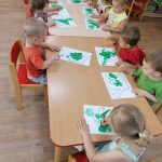 Dzieci malują konewki zieloną farbą