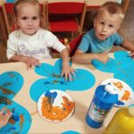 Chłopiec i dziewczynka malują farbami motylki