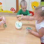 Dzieci malują rolki po papierze toaletowym na zielono