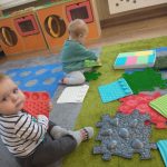 Dzieci na dywanie dotykają mat sensorycznych