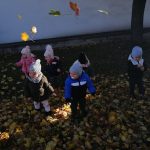 Dzieci bawią się na dworze wśród liści