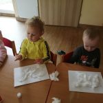 Dzieci wykonują pracę plastyczną z użyciem kleju i waty