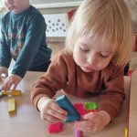 Dzieci układają konstrukcje z małych klocków