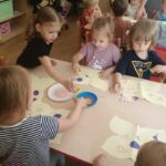 Dzieci malują motylki nakrętkami i farbąDzieci malują motylki nakrętkami i farbą