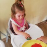 Dzieci malują kartkę z pomocą farby i gąbki