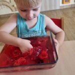 Dzieci biorą udział w zajęciach sensorycznych z galaretką owocową
