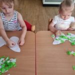 Dzieci wykonują pracę plastyczną z wycinanką z bibuły