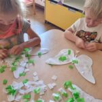 Dzieci wykonują pracę plastyczną z wycinanką z bibuły