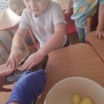 Dzieci kroją ziemniaki na frytki
