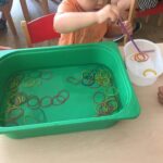 Dzieci wyławiają recepturki z wody za pomocą słomki