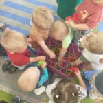 Dzieci wyciągają śrubki z pojemnika z przeszkodami