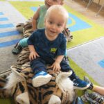 Dzieci bawią się pluszowym tygrysem