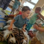 Dzieci bawią się pluszowym tygrysem