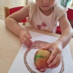 Dzieci wykonują pracę plastyczną z jabłkiem