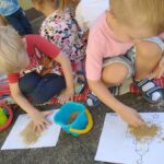 Dzieci wykonują pracę plastyczną z piaskiem i klejem