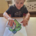 Dzieci kolorują kredkami i posypują kartkę brokatem