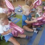 Dzieci bawią się balonowymi literkami