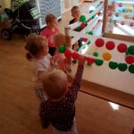 Dzieci przyklejają piłeczki na taśmę