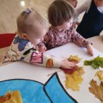 Dzieci wykonują pracę plastyczną z żywymi liśćmi