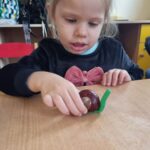 Dzieci robią ślimaki z kasztanów i plasteliny