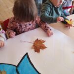 Dzieci wykonują pracę plastyczną z żywymi liśćmi