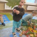 Dzieci na zajęciach sensorycznych z liśćmi i kasztanami