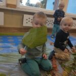 Dzieci na zajęciach sensorycznych z liśćmi i kasztanami