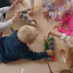 Dzieci bawią się patyczkami w dobieranie kolorów