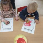Dzieci robią stempelki z jabłek na kartce