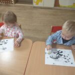 Dzieci odbijają kropki na papierze stempelkami