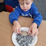 Dzieci dekorują gwiazdki sztucznym śniegiem