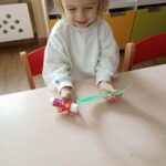 Dzieci robią wianuszki świąteczne z papieru i pomponików
