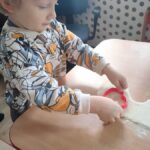 Dzieci wycinają pierniczki z masy solnej za pomocą foremek