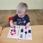 Dzieci przy zabawach manipulacyjnych z książeczkami sensorycznymi