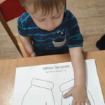 Dzieci odbijają rączki na papierze