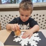 Dzieci malują śnieżynki za pomocą gąbeczek