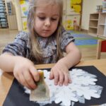 Dzieci malują śnieżynki za pomocą gąbeczek