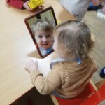 Dzieci pokazują części twarzy w lustrze