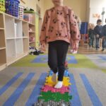 Dzieci stymulują stópki na ścieżce sensorycznej