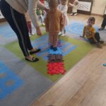 Dzieci stymulują stópki na ścieżce sensorycznejDzieci stymulują stópki na ścieżce sensorycznej