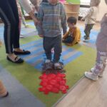 Dzieci stymulują stópki na ścieżce sensorycznej