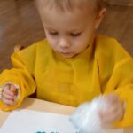 Dzieci malują na kartce folią bąbelkową