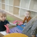 Dzieci układają piankowe puzzle z literkami