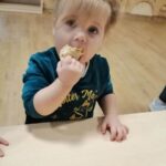 Dzieci jedzą naleśniki na Dzień Naleśnika w żłobku