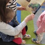 Dzieci oglądają książeczki o dinozaurach